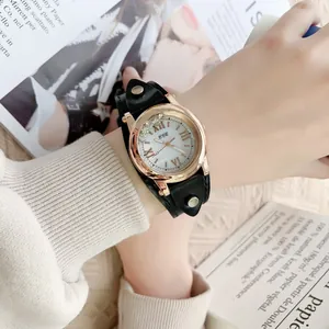 Détail de la montre or rose avec strass et bracelet noir en cuir double épaisseur