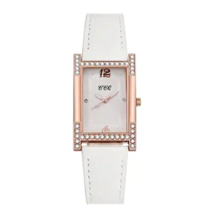 Close-up of square rose gold case with crystal H-shape and white leather strap
