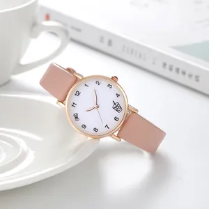 Détail du bracelet en cuir rose et boîtier doré rose avec icônes sur le cadran blanc