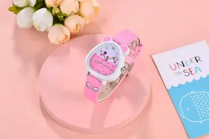 Cute pink girls quartz watch with cat ear case and white wing strap on a display stand