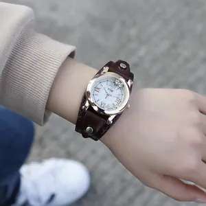 Montre femme en or rose avec bracelet en cuir marron et chiffres romains au poignet