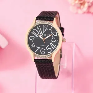 Montre femme tendance en or rose avec lunette en strass et bracelet en cuir noir