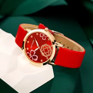 Elegant women's watch with red leather strap and golden floral dial on green velvet