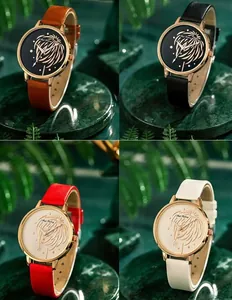 Détails de montres à quartz élégantes avec boîtier or rose et motifs de plumes sur marbre