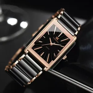 Macro detail of rectangular quartz watch with black sunray dial and rose gold accents