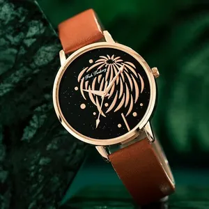 Détail du boîtier en or rose avec cadran floral et bracelet en cuir marron pour femmes