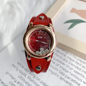 Détail de montre à bracelet large en cuir rouge avec chiffres romains et cristaux