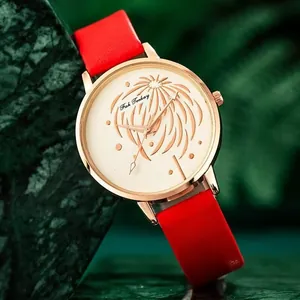 Gros plan d'une montre pour femme avec boîtier or rose et bracelet en cuir rouge vif