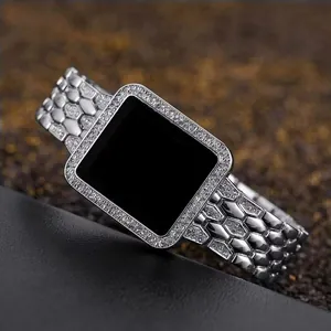 Macro detail of luxury silver rhinestone encrusted watch case and hexagonal scale strap