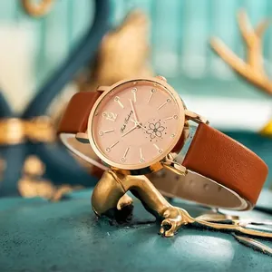 Modische Damenarmbanduhr in Roségold mit Blumenzifferblatt auf goldenem Geweihständer