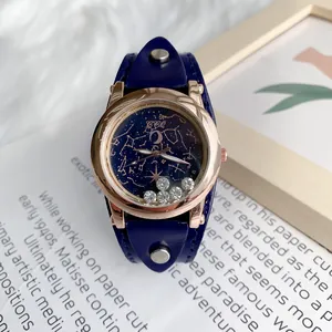 Gros plan du cadran ciel étoilé avec cristaux mobiles et bracelet en cuir bleu à rivets