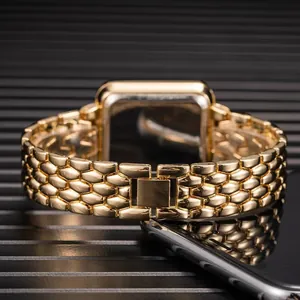 Detail of the golden metallic scale-link strap and folding clasp on a square watch