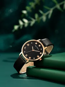 Detalle de reloj en oro rosa con esfera de cielo estrellado y cristales sobre libro