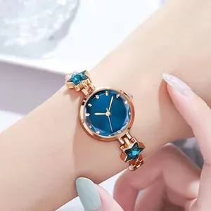 Women's rose gold watch with deep blue dial and star-shaped crystal accents on the strap