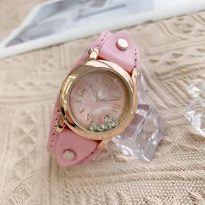 Détail de montre en cuir rose avec strass mobiles et cadran à chiffres romains