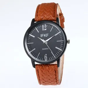 Detailed macro of vintage quartz watch with brown textured leather strap and black dial