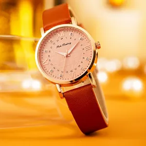 Dettaglio quadrante oro rosa con motivo a globo e cinturino in pelle marrone su sfondo fine
