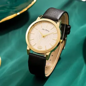Gros plan de la montre dorée avec détail lotus et bracelet en cuir noir sur soie verte