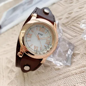 Détail macro de la montre rétro en cuir avec boîtier en or rose et strass mobiles