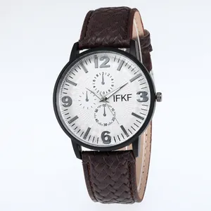 Makroaufnahme des braunen Lederarmbandes mit Prägung und weißem Zifferblatt der Uhr