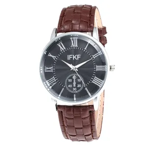 Detail of silver watch case with black dial featuring Roman numerals and leather strap