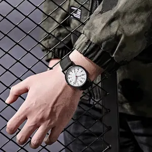 Orologio militare luminoso con cinturino in nylon e cassa nera su sfondo industriale