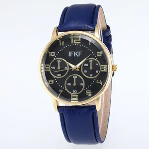 Close-up of business watch with blue leather strap, gold case, and black wave dial