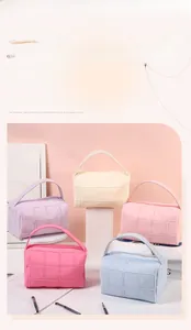 Detailed view of quilted makeup bags with top handles in vibrant dopamine color palette