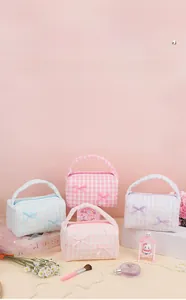Macro shot of colorful checkered toiletry bags with ribbon bows in pastel macaron shades