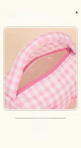 Detail of pink gingham makeup bag featuring white lace trim and heart-shaped zipper