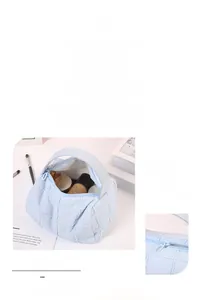 Detail showing light blue quilted makeup bag with zipper closure and soft cotton texture