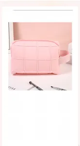Detail of pink quilted makeup bag showing soft texture and convenient side carrying handle