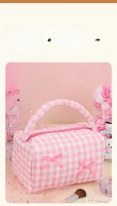 Detailed view of pink plaid makeup bag with cute bow accents and smooth zipper closure