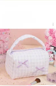 Detail of lavender checkered quilted makeup bag showing large opening design and carry handle