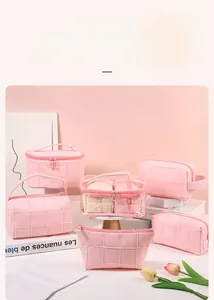 Pink quilted travel makeup bag set with zipper details and textured stitching design