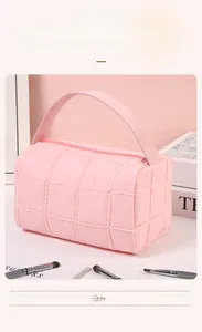 Detailed view of pink quilted checkered toiletry bag with soft fabric and zipper