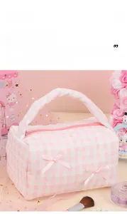 Detail of pink plaid quilted cotton makeup bag with lace trim and bow handle