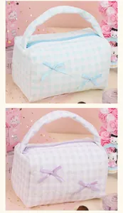 Close-up of quilted cosmetic bags with checkered pattern and silk bow details