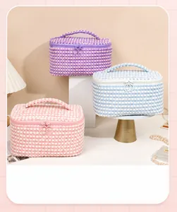 Three two-tone plush cosmetic bags in pink, purple, and blue with round zipper pullers