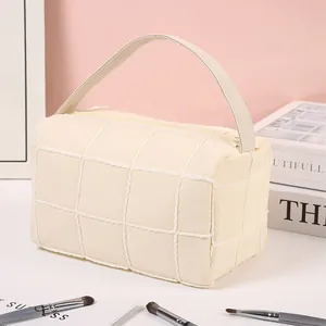 Checkerboard cream fleece makeup bag with top handle and quilted lamb wool texture