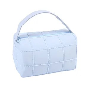 Light blue quilted checkered makeup bag with sturdy handle and zipper closure for travel