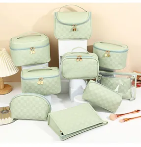 Detail of mint green checkered makeup bags with cat-shaped golden zippers on white stands