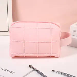 Pink quilted checkerboard travel makeup bag with handle and zipper closure for women