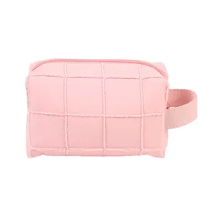 Pink quilted travel makeup bag with reinforced handle and zipper on white background