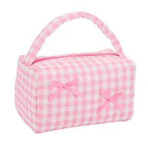 Quilted pink gingham makeup bag with bow accents and top handle for travel storage