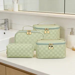 4-piece mint green checkerboard cosmetic bag set on a white marble bathroom counter