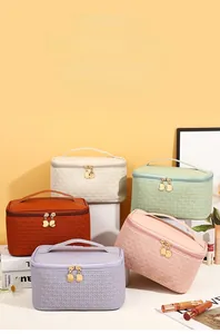 Detailed view of portable PU leather cosmetic bags with elegant woven texture and gold zippers