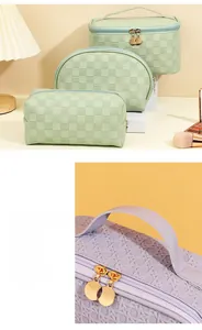 Detail of wide handle and golden metal zippers on a purple woven textured toiletry bag