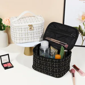 Elegant tweed makeup bag with top handle and gold zipper shown in a beauty setting