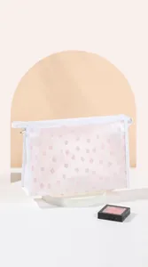 Close-up of white mesh cosmetic bag with pink floral patterns and side handle